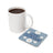 White mug of coffee next to a light blue coaster with white daisies and "DEEP BREATHS" text.