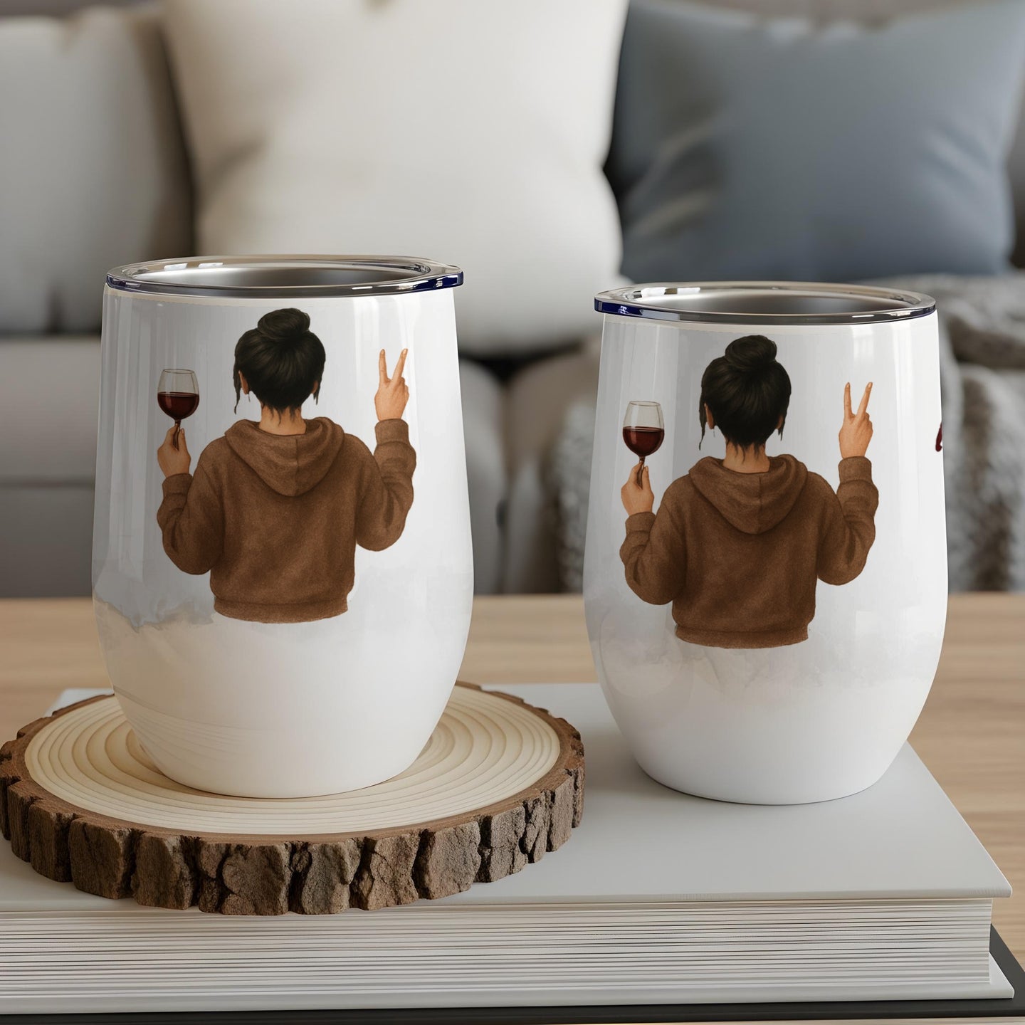 Two insulated tumblers featuring a woman in a brown hoodie holding wine.