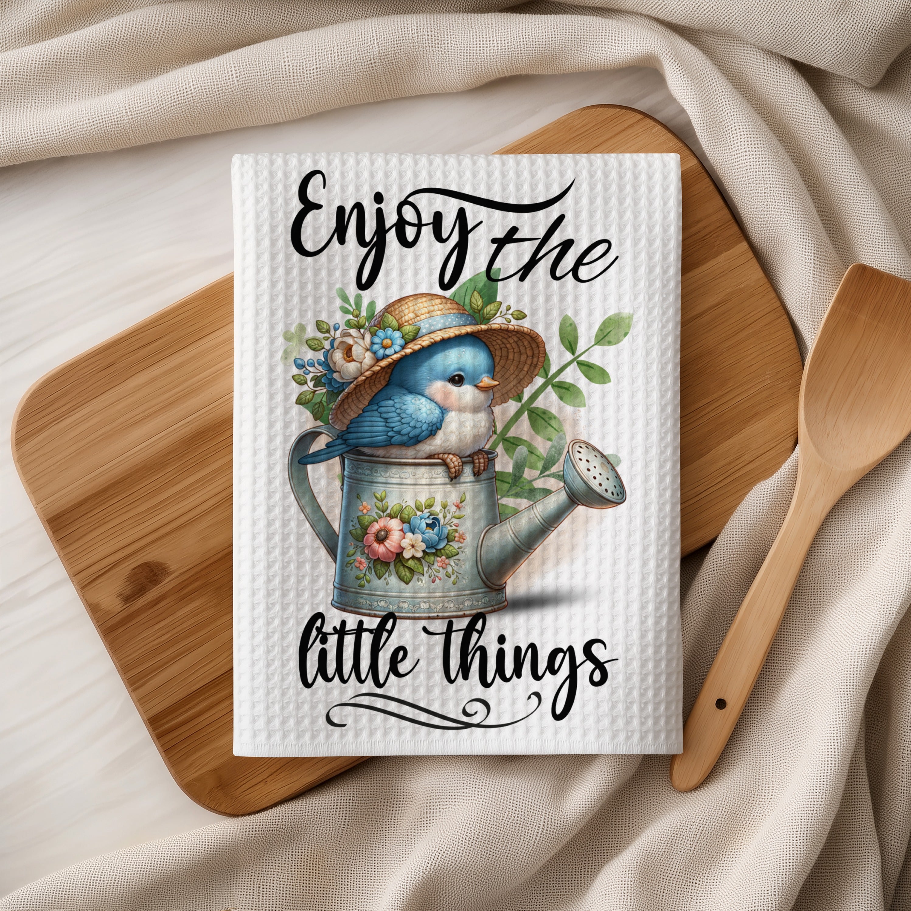 Bluebird wearing a straw hat perched on a watering can with flowers.
