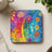Square coaster with a rainbow arch of colorful cartoon flowers.