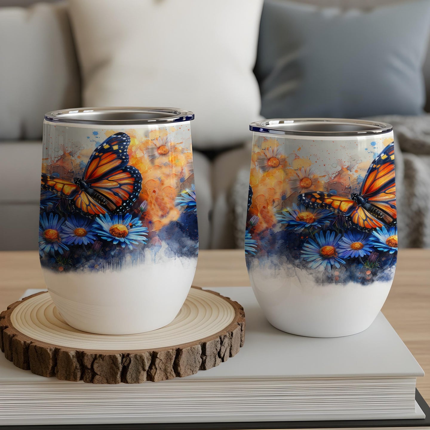 Two wine tumblers with monarch butterflies and blue flowers design.