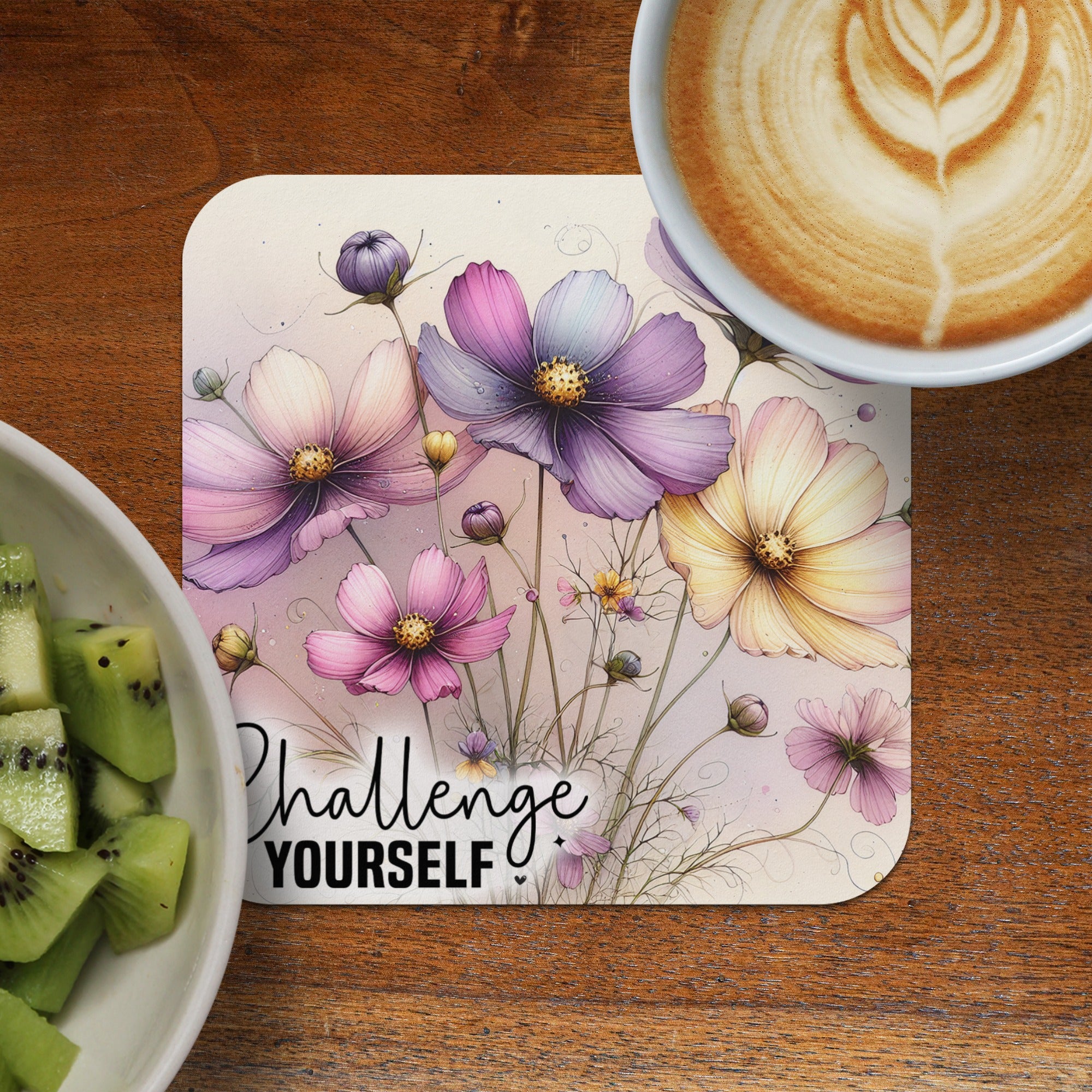 Floral design on coaster with text "Challenge YOURSELF" next to kiwi and coffee.
