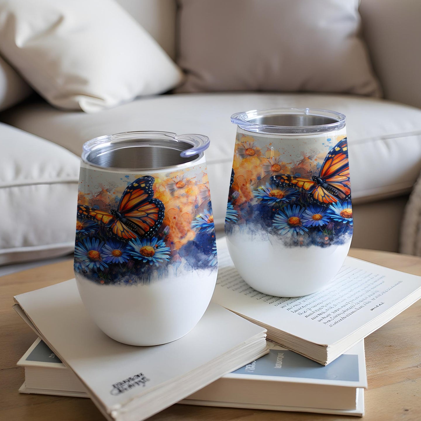 Two white tumblers with monarch butterflies and blue flowers.
