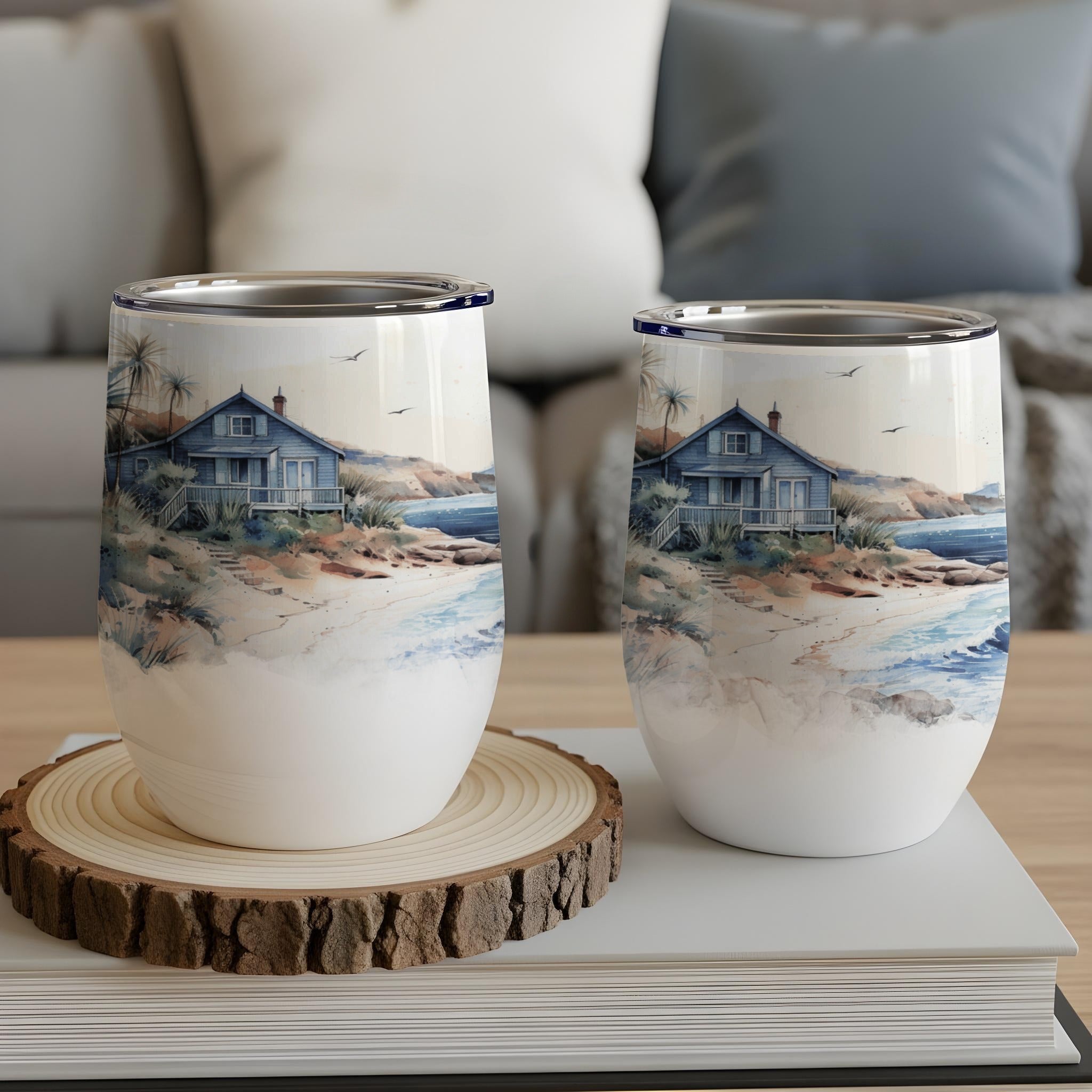 Two insulated tumblers with a beach house and ocean scene.