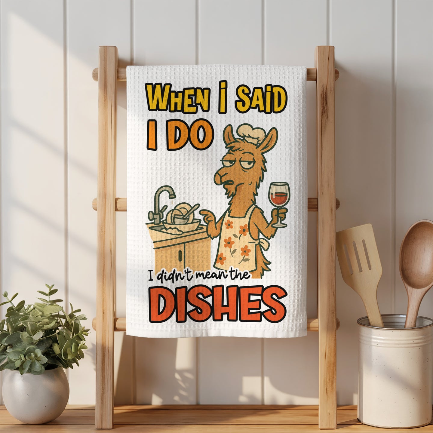 Towel with llama wearing apron, holding wine glass, saying "I didn't mean the dishes."