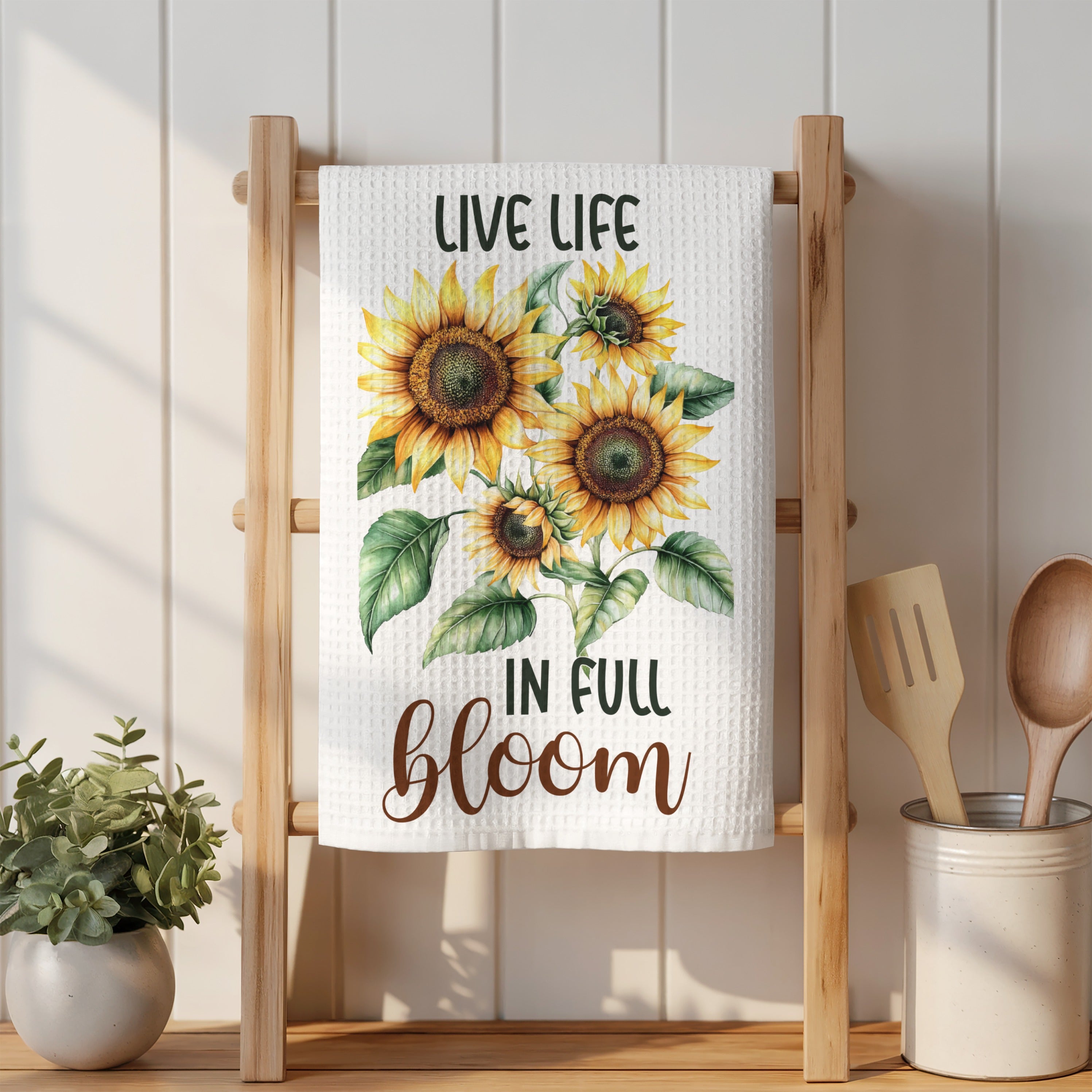 White kitchen towel with sunflowers and text "LIVE LIFE IN FULL BLOOM".
