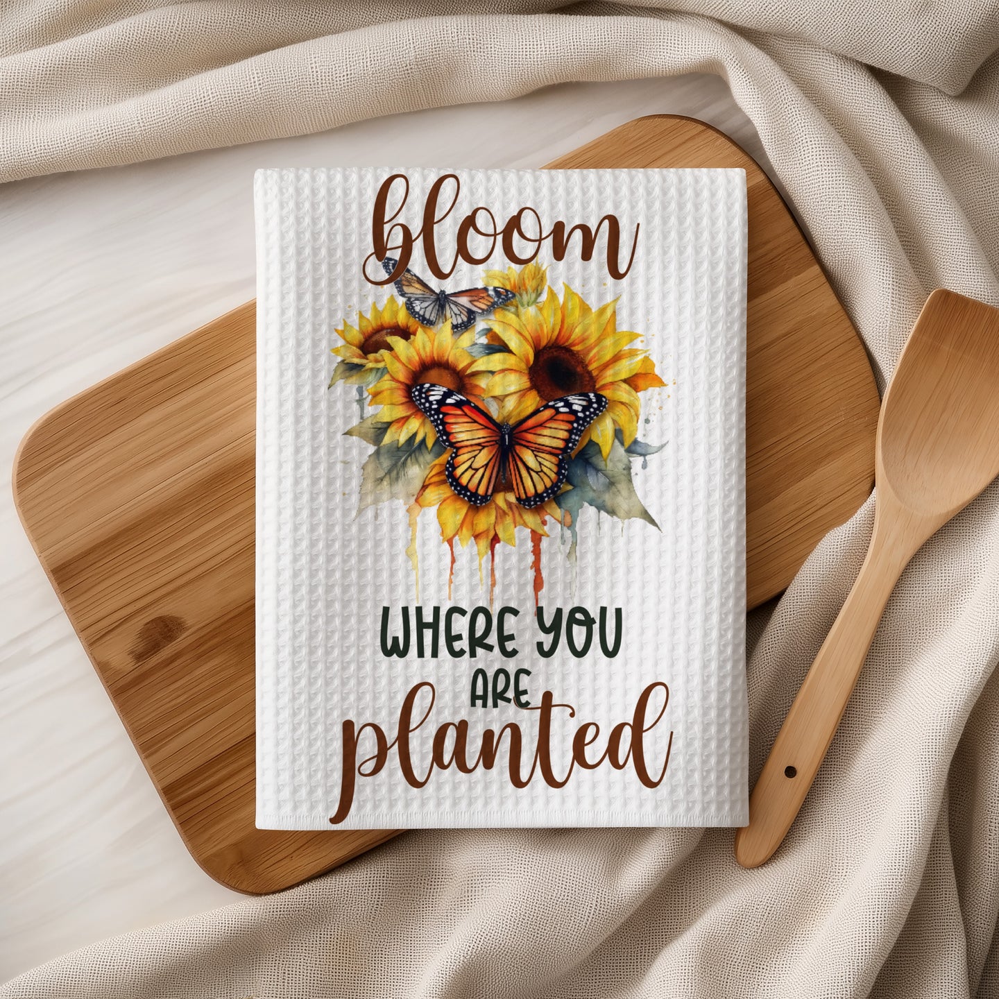Waffle weave towel with sunflowers, butterflies, and "bloom where you are planted" text.