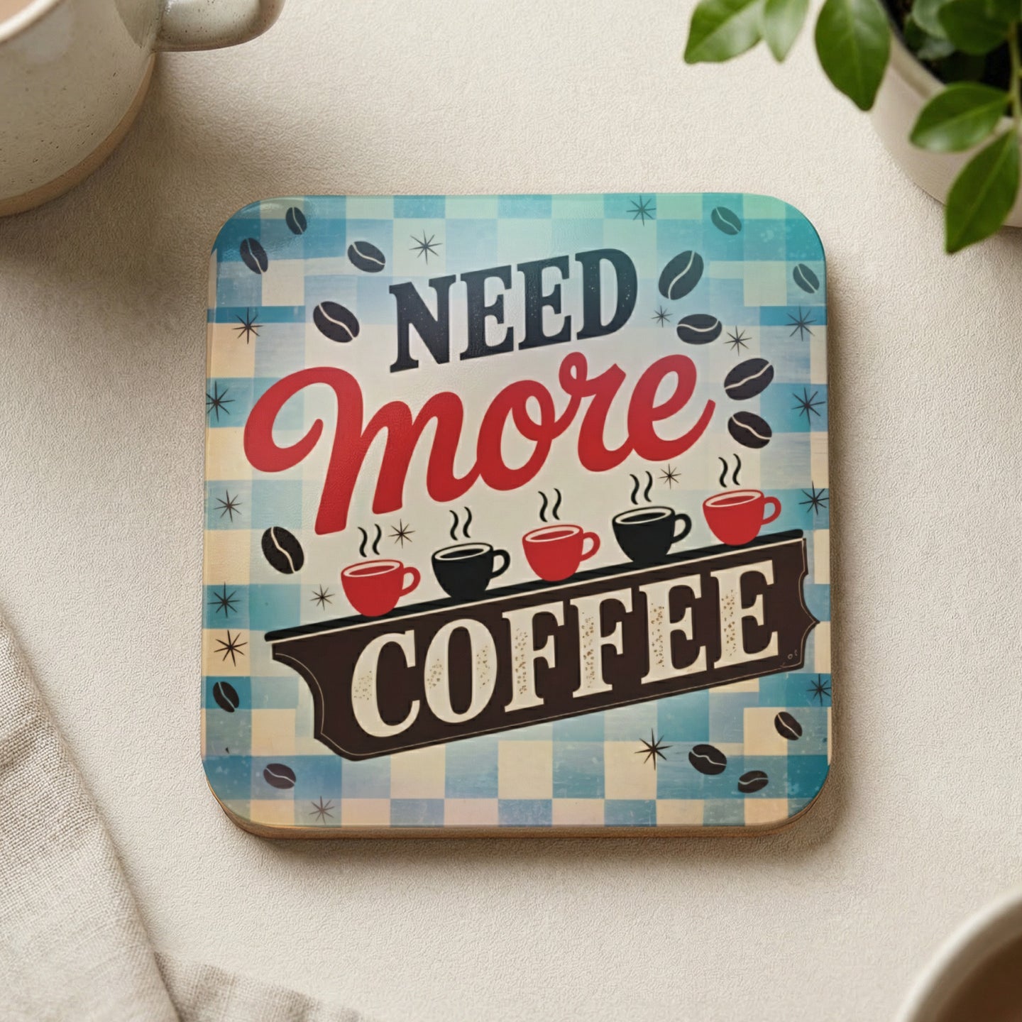 "Need More Coffee" graphic with coffee cups on a checkered background.