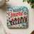 "Need More Coffee" graphic with coffee cups on a checkered background.