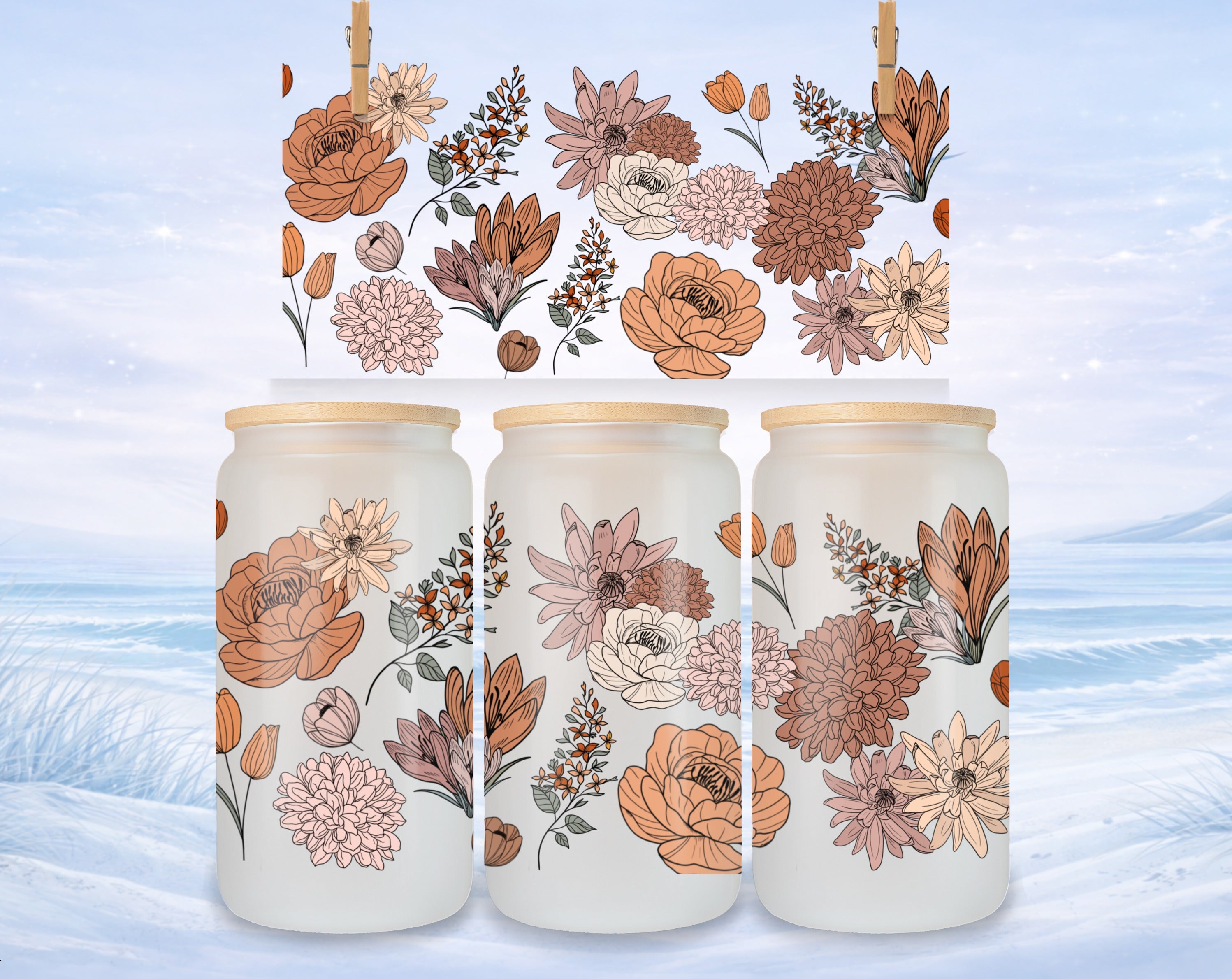 Three frosted glass tumblers with floral patterns against a snowy background.