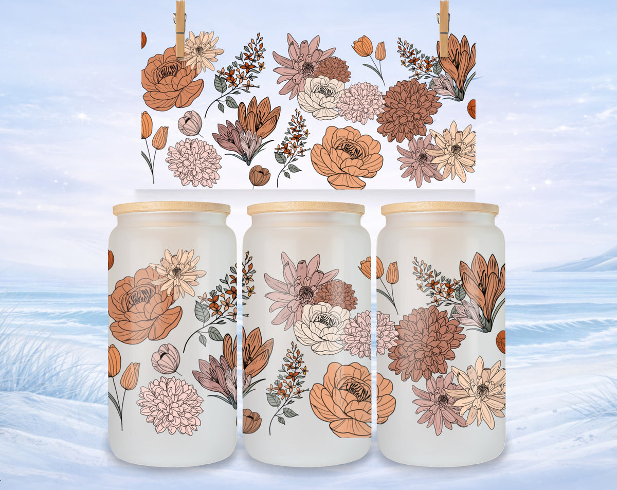 Three frosted glass tumblers with floral patterns against a snowy background.