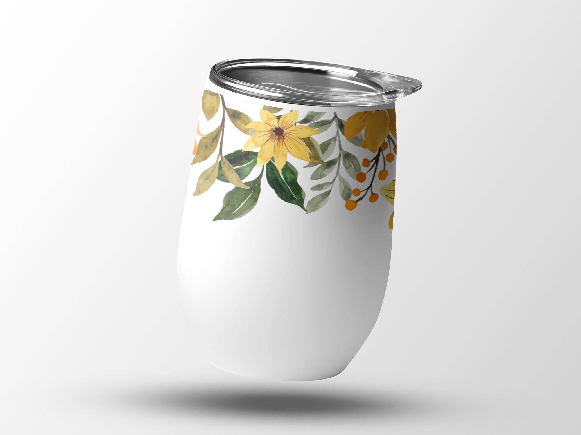 White tumbler with a floral pattern of yellow flowers and green leaves.
