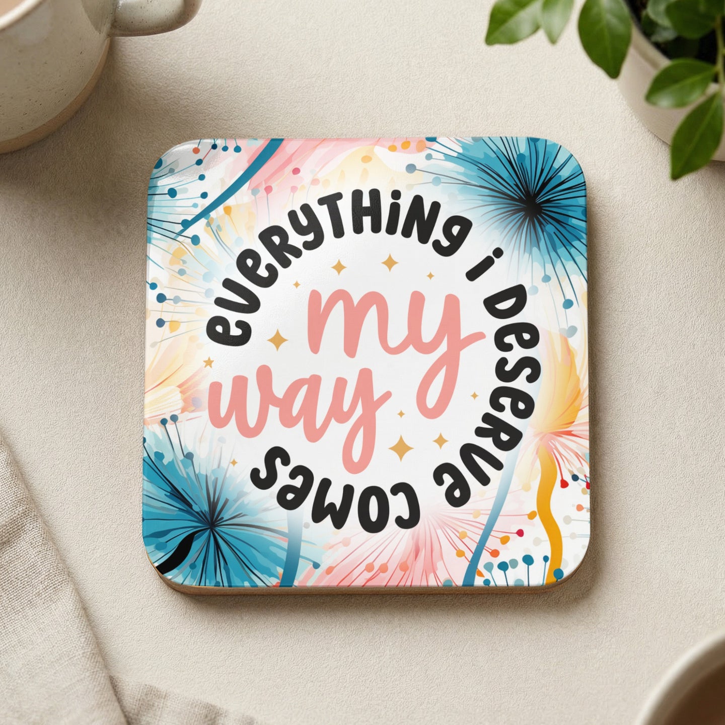 Coaster with pink text "Everything my way i deserve comes" on a floral background.
