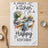 Kitchen towel with watercolor art of dishes in a sink and text "A messy kitchen is a happy kitchen".