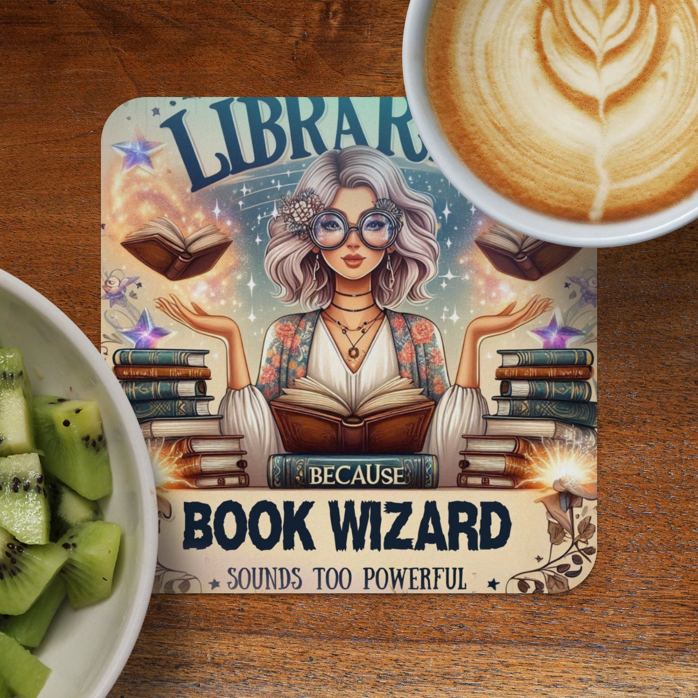 Book Wizard coaster with woman surrounded by books, latte, and sliced kiwi.