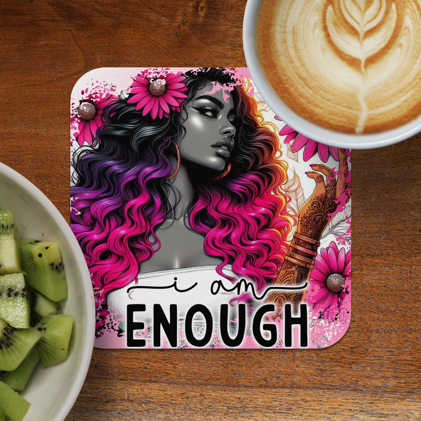 Woman with colorful hair on "I am ENOUGH" coaster, with coffee and kiwi.