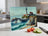 Lighthouse on a rocky coast with crashing waves, beside sliced tomatoes and cucumber.