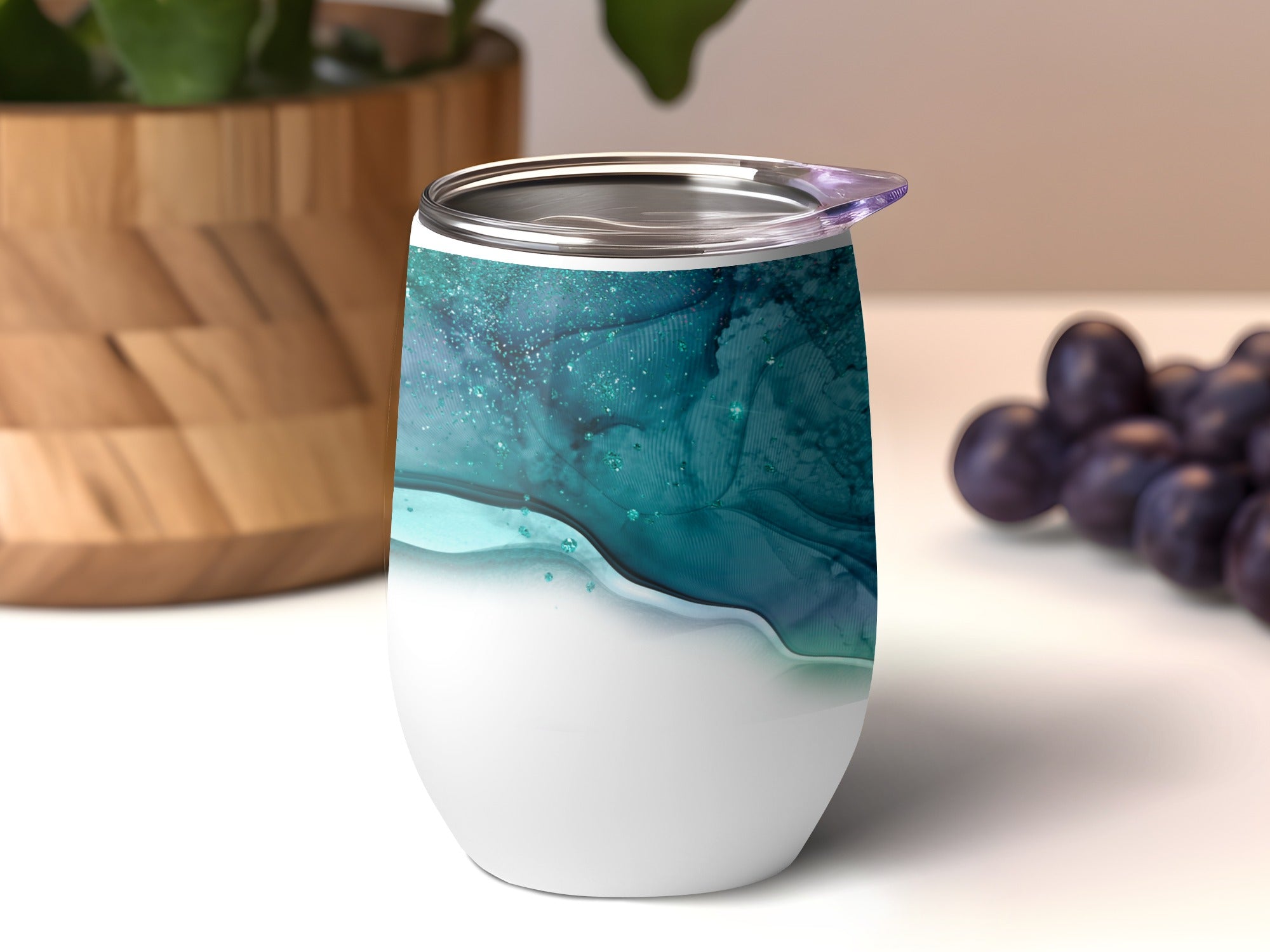 White stemless wine tumbler with blue and green abstract marble design.
