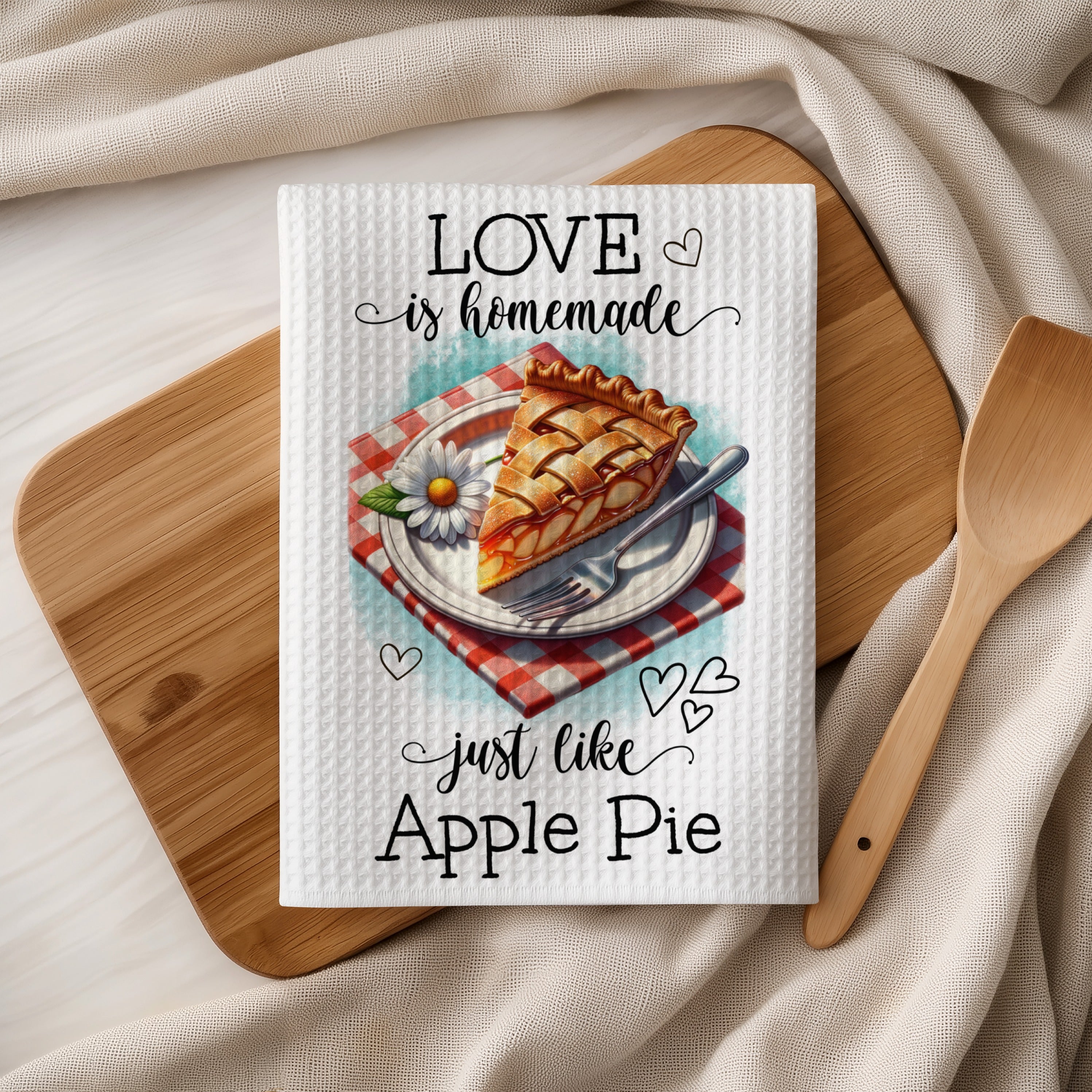 Waffle weave towel with "Love is homemade, just like Apple Pie" text and a pie slice.