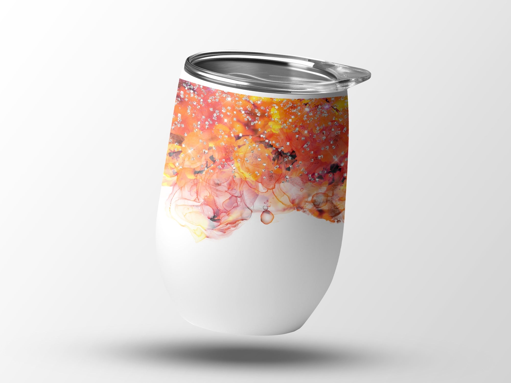 White tumbler with abstract orange and yellow paint splatter design.