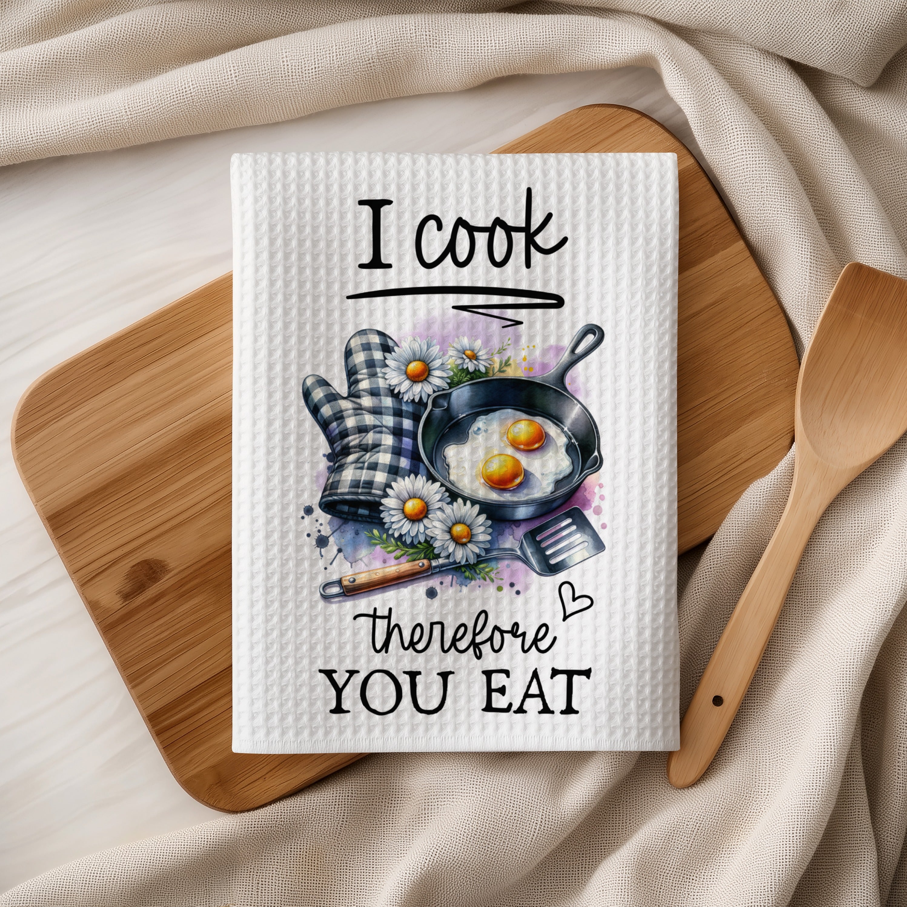 Kitchen towel with fried eggs, daisies, and "I cook therefore you eat" text.
