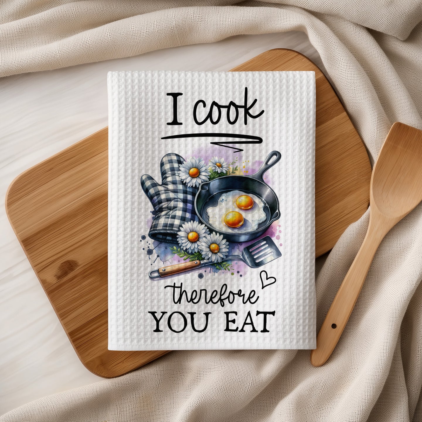 Kitchen towel with fried eggs, daisies, and "I cook therefore you eat" text.