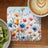 Coaster with colorful wildflowers and a coffee with latte art.