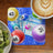 Bingo cards with numbers, colorful bingo balls, sliced kiwi, and coffee on a wooden table.