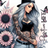 Tattooed woman in black crop top and jeans, surrounded by sunflowers and butterflies.