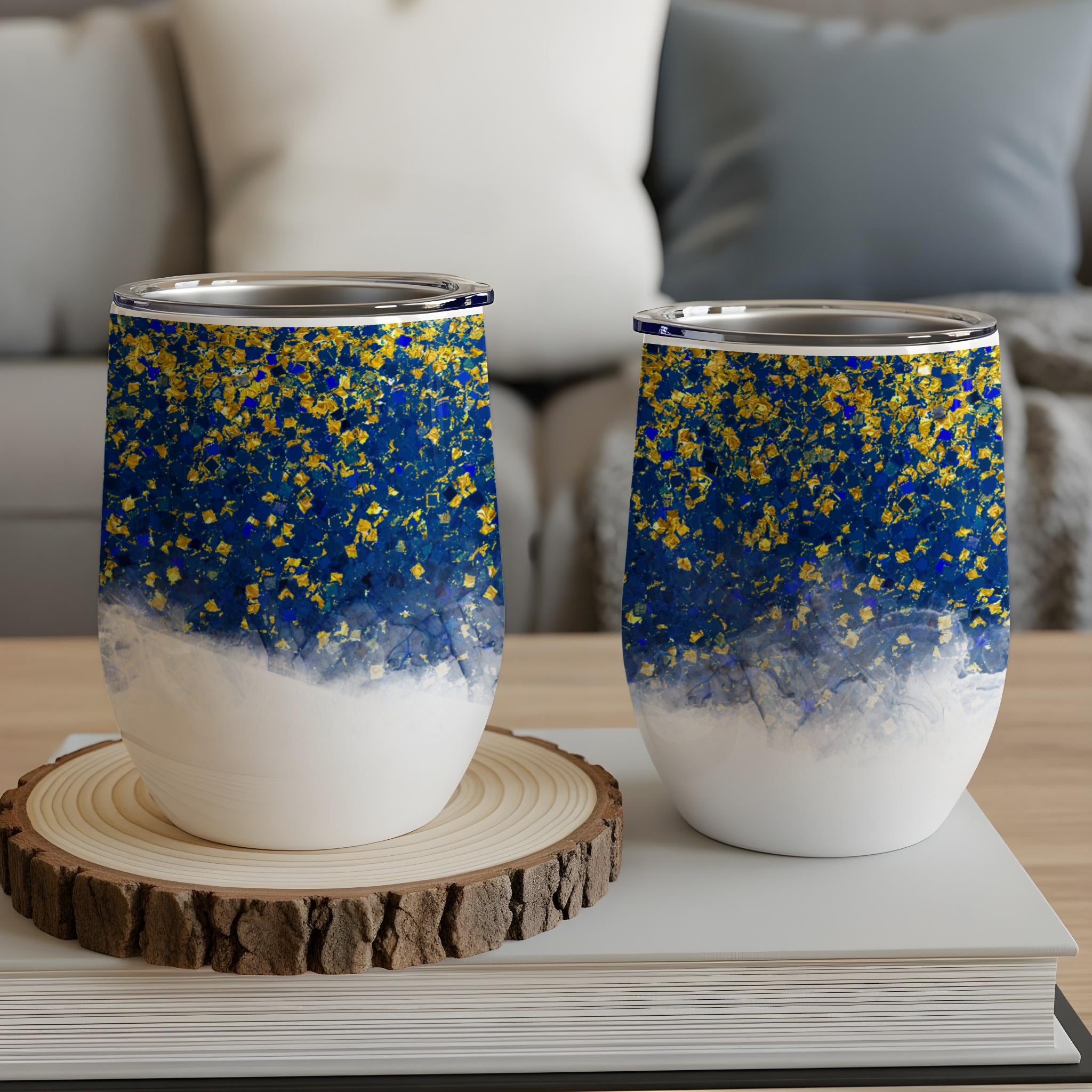 Two insulated wine tumblers with blue and gold glitter design.