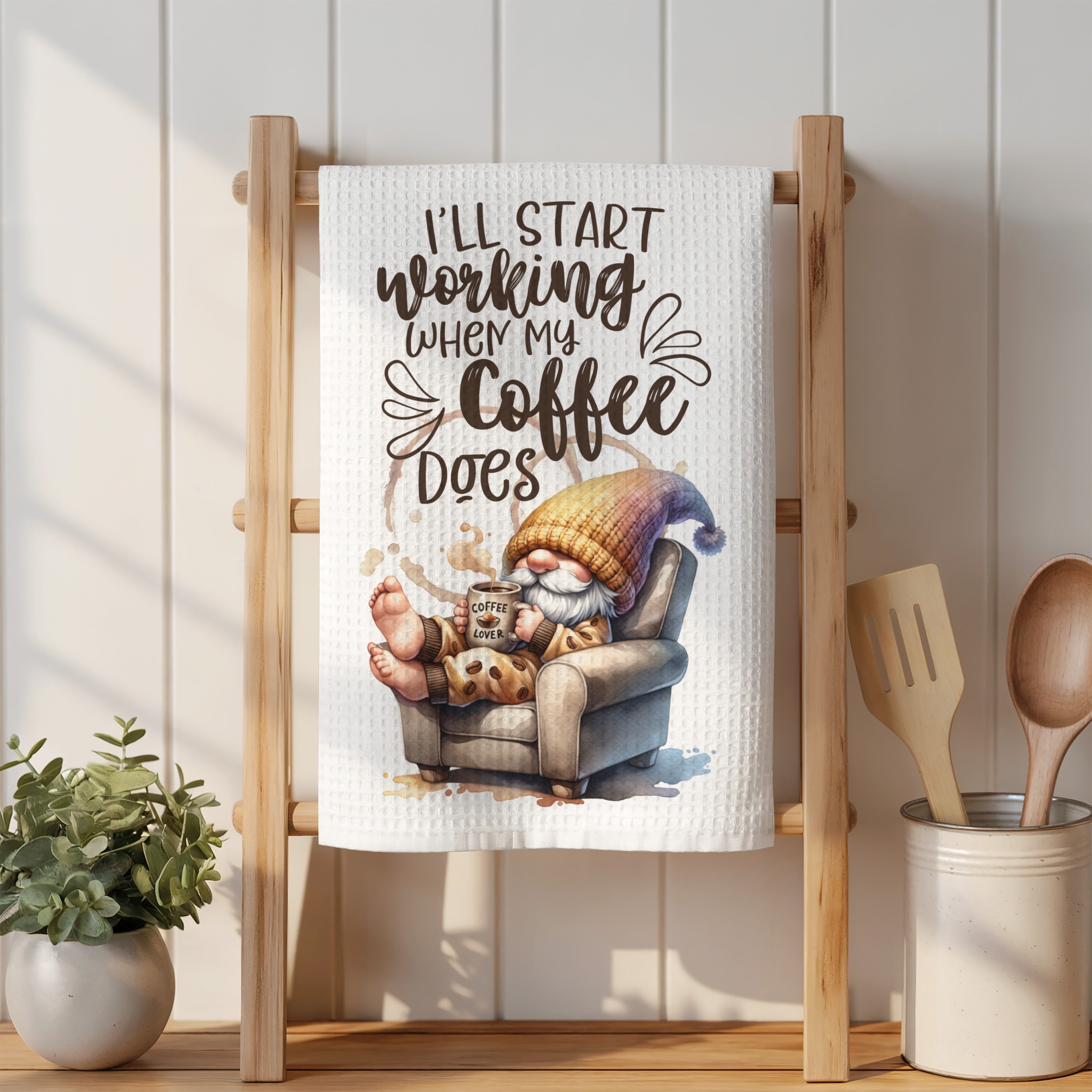 Gnome with coffee mug relaxing in chair, text "I'll start working when my coffee does."