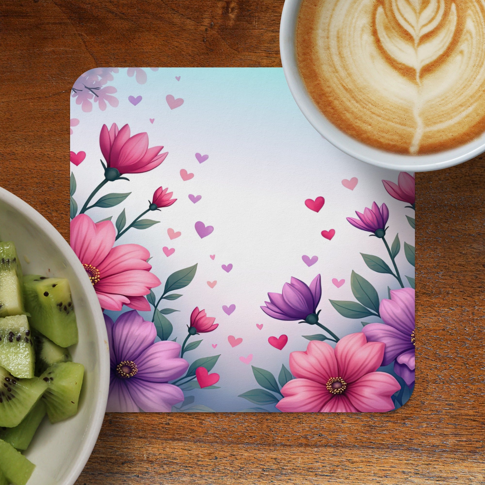 Floral design placemat with hearts and a cup of coffee and kiwi slices.