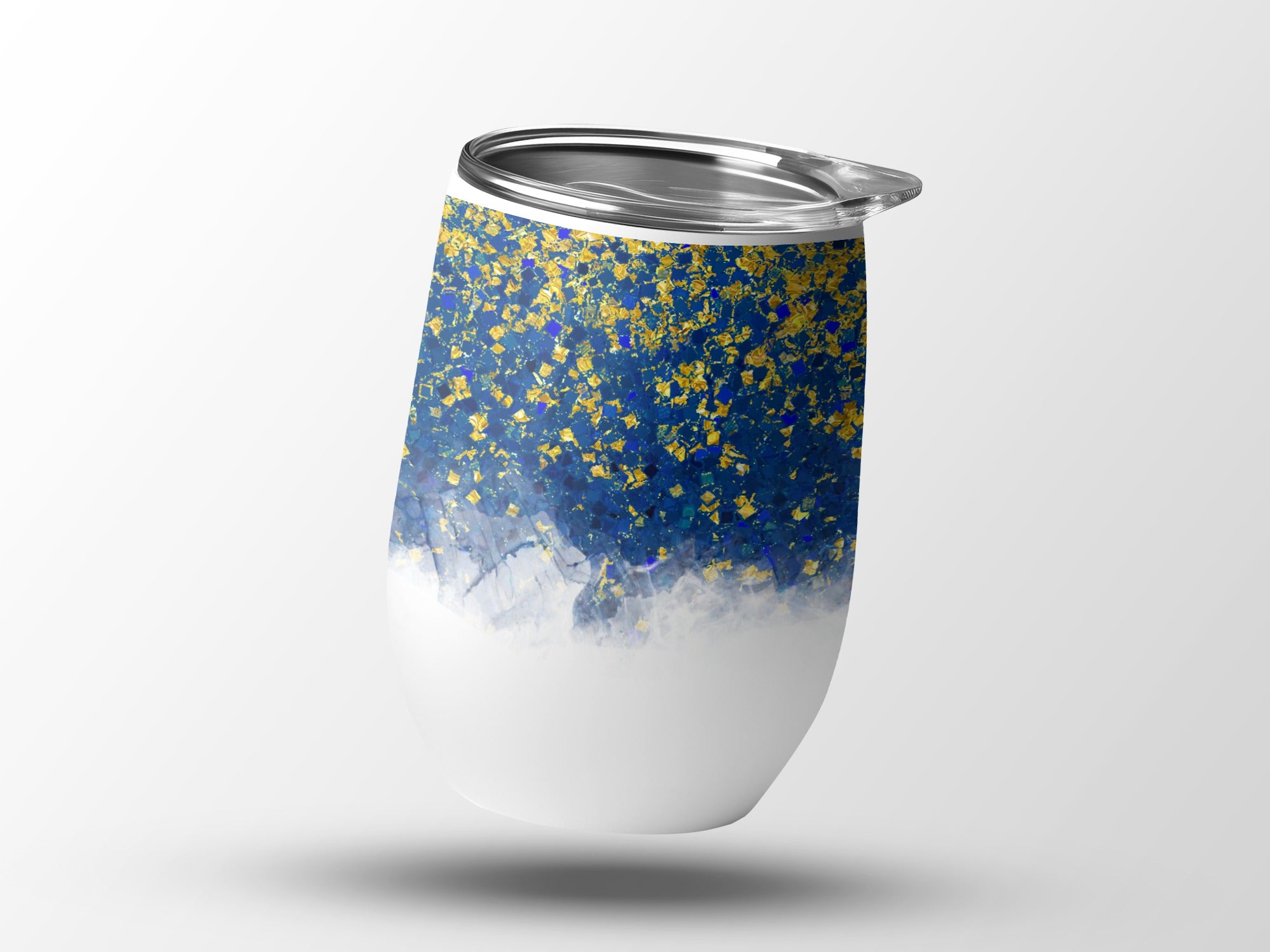 White tumbler with blue and gold abstract splatter design and silver lid.