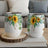 Two white wine tumblers with sunflower and eucalyptus design.