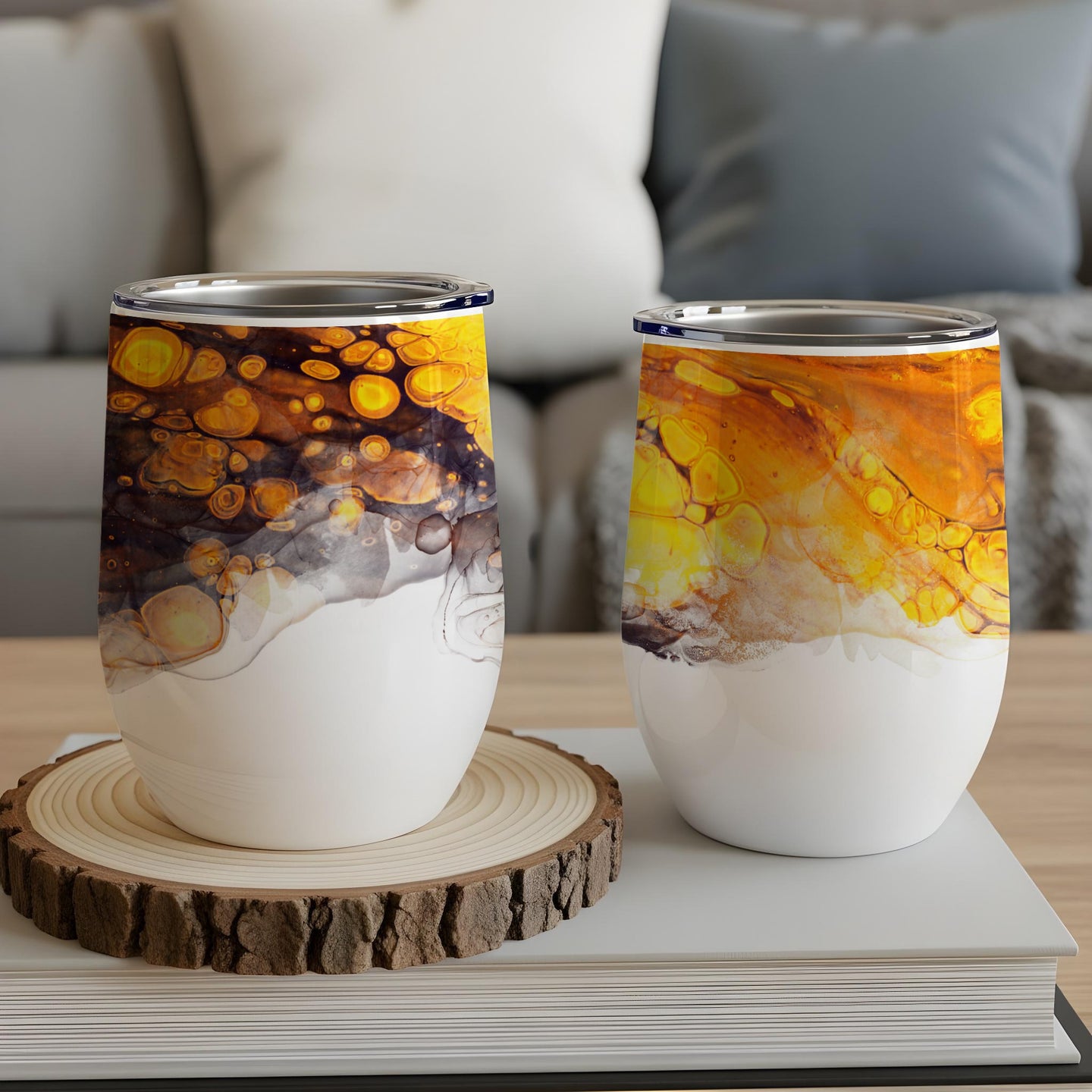 Two white tumblers with abstract orange and yellow marbled designs.