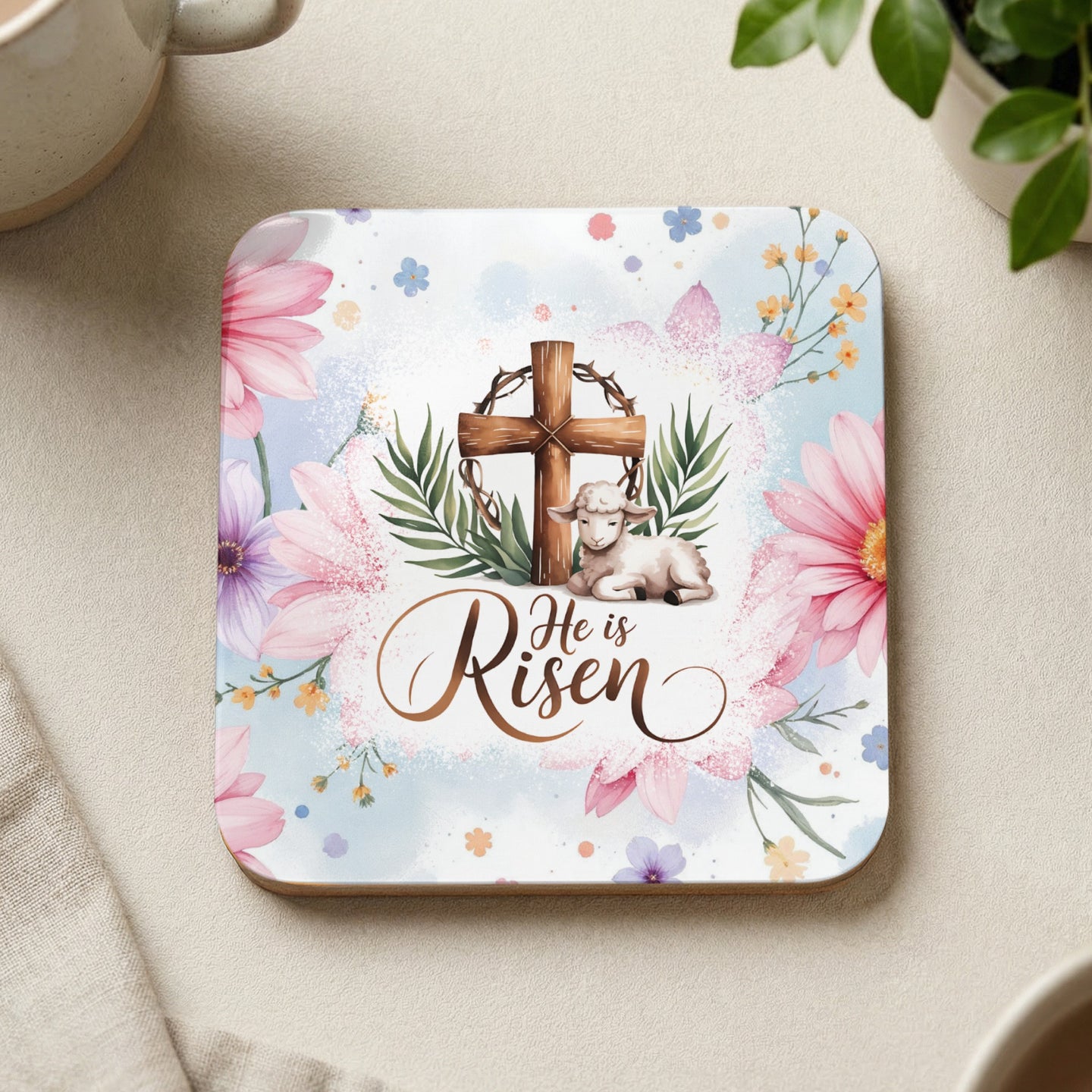 Square coaster with "He is Risen" text, a lamb, and a cross surrounded by flowers.