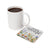 White mug of coffee next to a coaster with "HAVE COURAGE AND BE KIND" text and floral design.