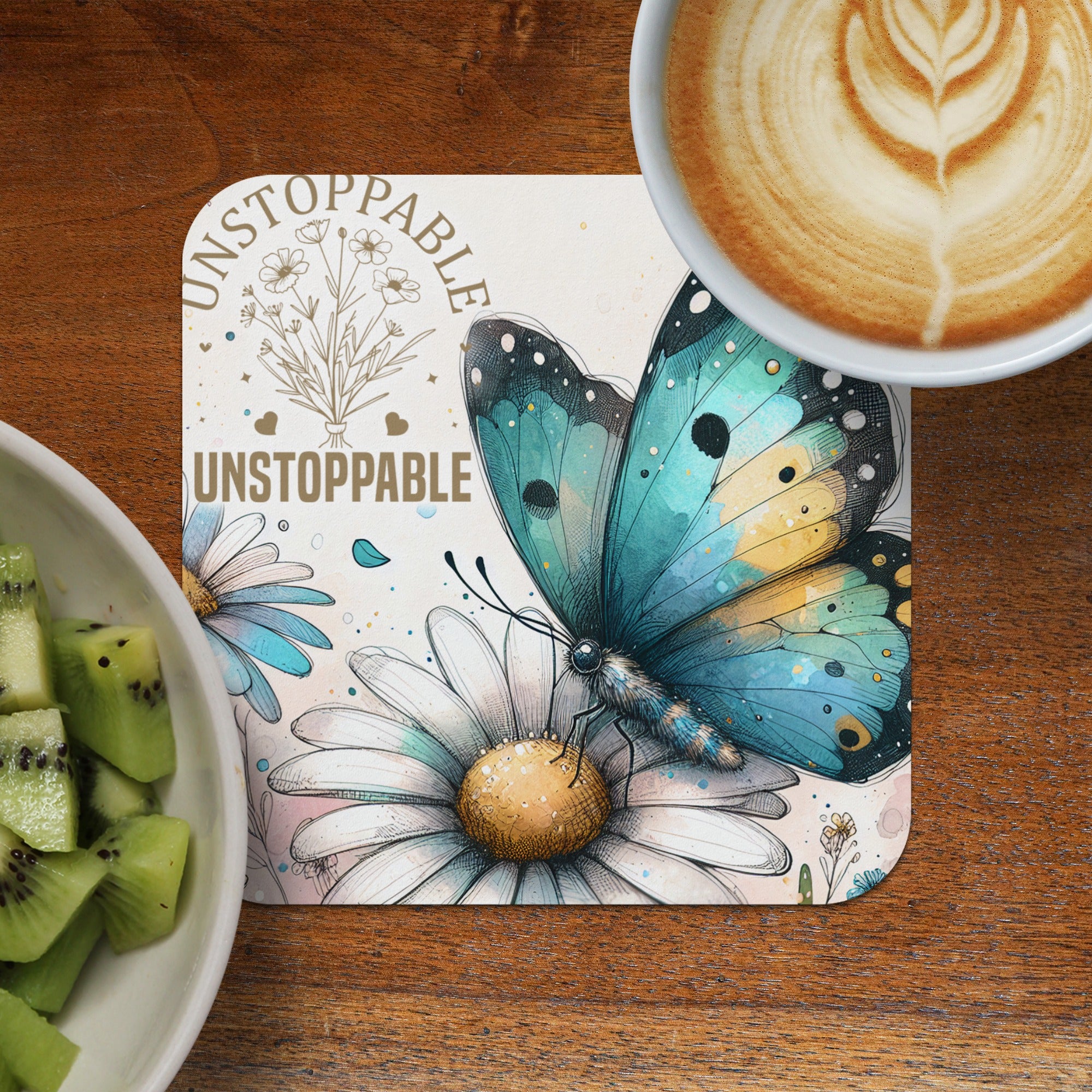 Turquoise butterfly on daisy, "UNSTOPPABLE" text, latte, and kiwi.