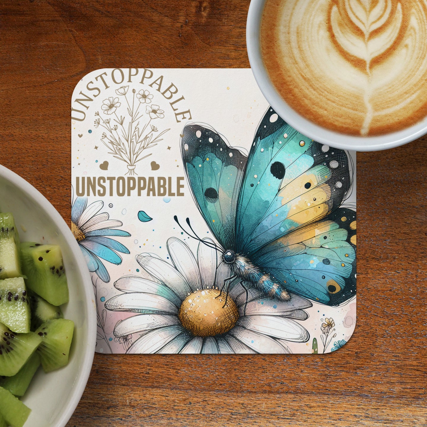 Turquoise butterfly on daisy, "UNSTOPPABLE" text, latte, and kiwi.