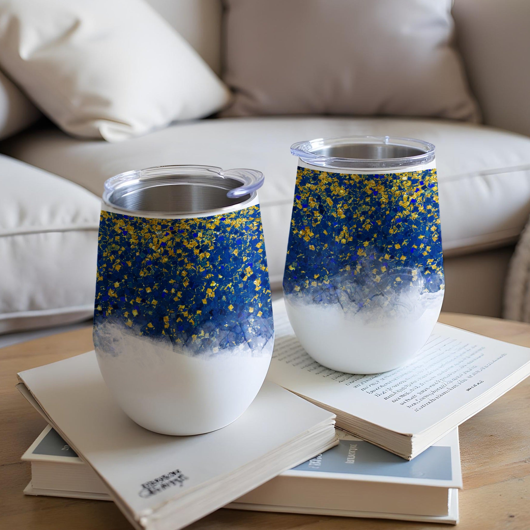 Two blue and gold speckled tumblers on a book.