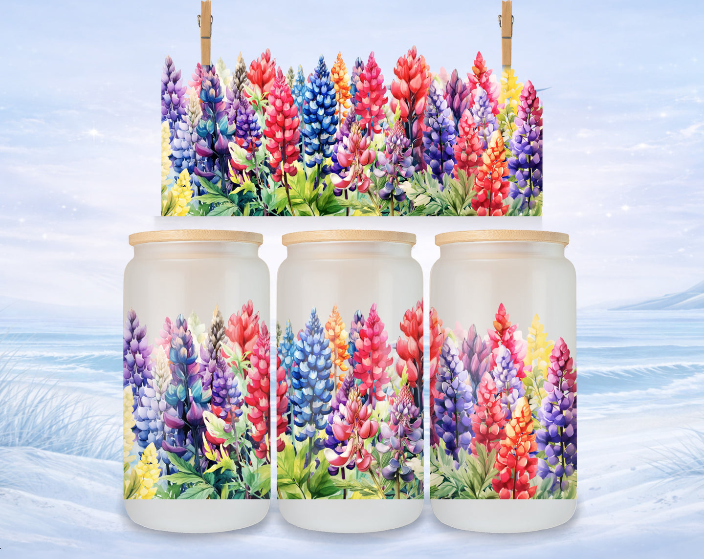 Lupine flowers in a rainbow of colors decorate three glass jars on a snowy landscape.