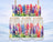 Lupine flowers in a rainbow of colors decorate three glass jars on a snowy landscape.
