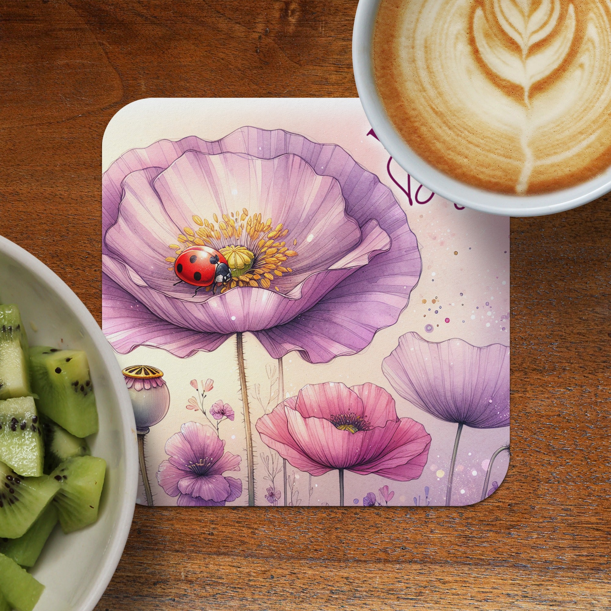 Round coaster with purple poppies and ladybug, beside kiwi slices and coffee.