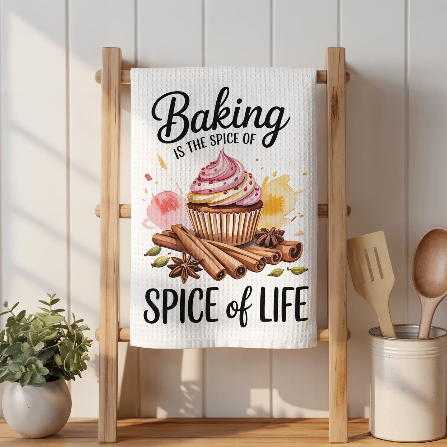Kitchen towel with cupcake, cinnamon sticks, and "Baking is the spice of life" text.