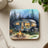 Retro camper trailer with campfire and chairs in a forest setting.