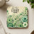 Coaster with "be the LIGHT" text and green floral watercolor design.