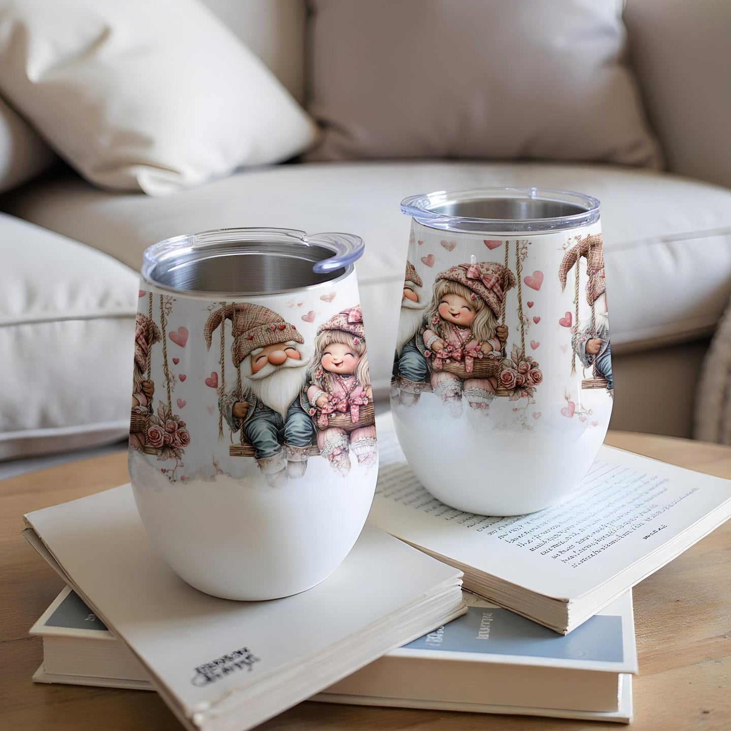 Two gnome cups with hearts and floral accents, resting on books.
