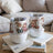 Two gnome cups with hearts and floral accents, resting on books.