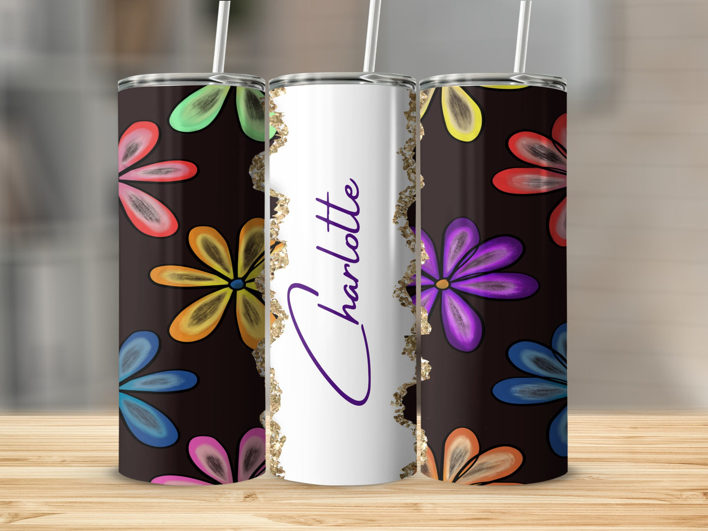 Black tumbler with colorful floral pattern and "Charlotte" in glitter.