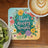 Coaster with "Think Happy Thoughts" text and colorful floral border.